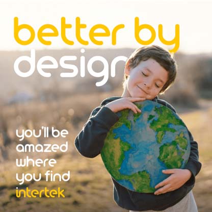 A boy hugging a model of the earth outdoors and smiling